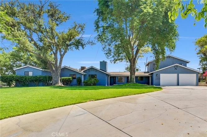 Spacious single-story blue house with a large driveway, two-car garage in California