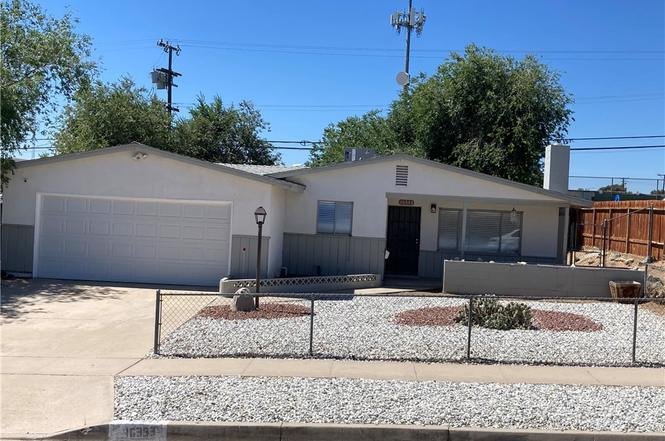 outside of a single-story house with white garage in California.
